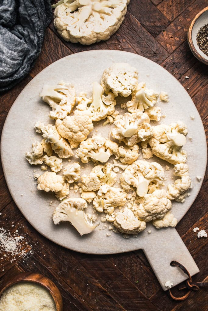 Cauliflower florets on cutting board. 