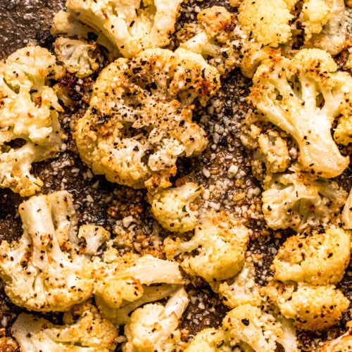 Roasted cacio e pepe cauliflower florets on baking sheet.