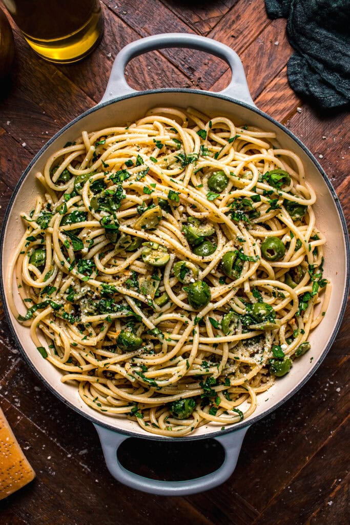 Pasta in skillet tossed with olives.