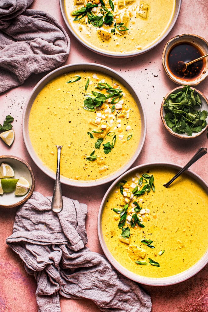 Bowls of curry corn chowder before topping with ingredients. 