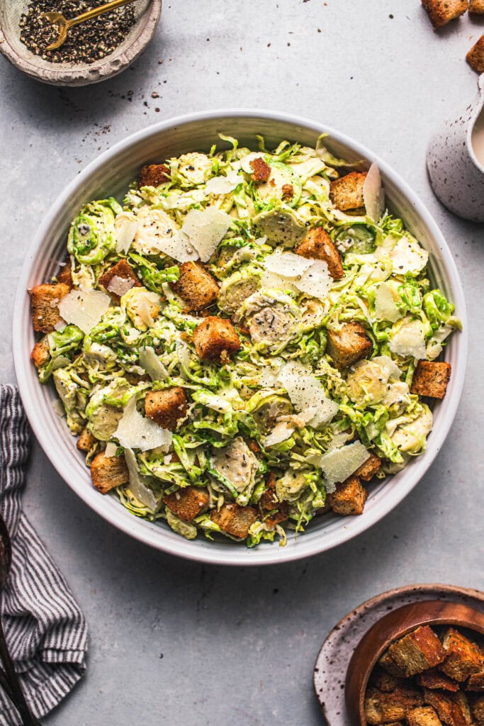 Finished burssel sprout caesar salad in bowl ready to serve. 