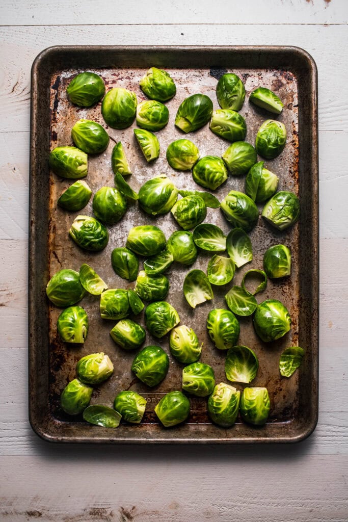 Trimmed brussel sprouts on baking sheet before roasting. 