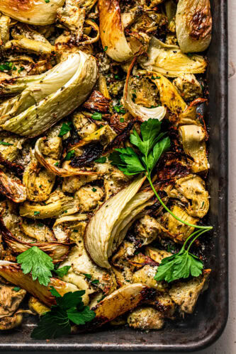 Overhead close up of roasted fennel and artichoke hearts on baking sheet.