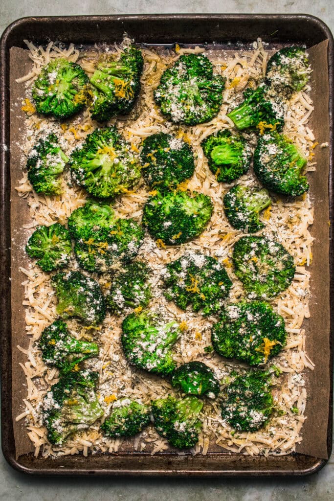 Broccoli and parmesan spread on baking sheet.
