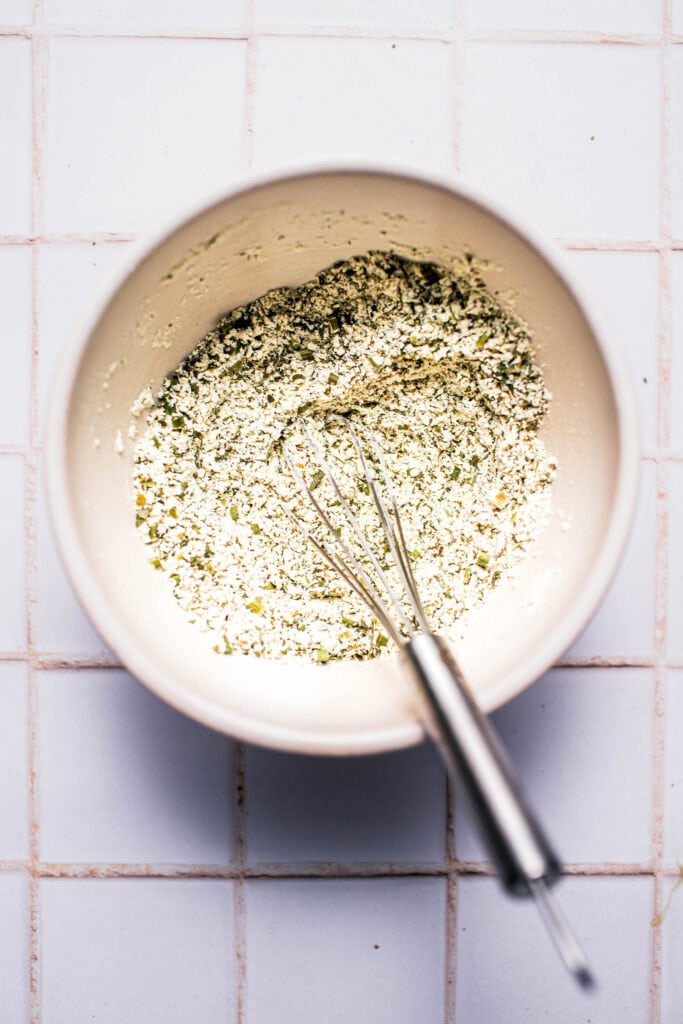 Ranch seasoning being whisked together in bowl.