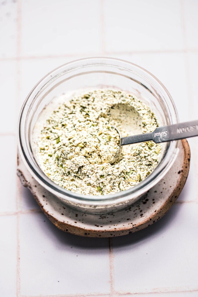 Side view of homemade ranch seasoning in bowl with spoon.