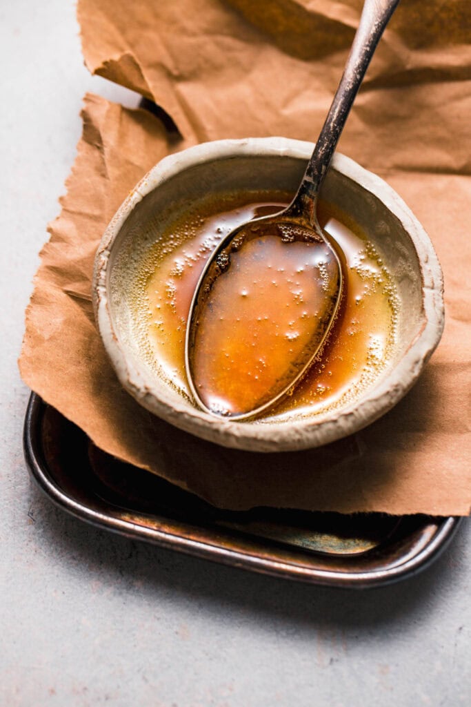 Browned butter in small bowl with spoon. 