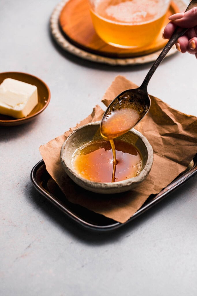 Spoon drizzling browned butter. 