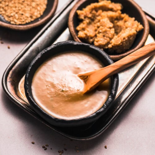 Side view of bowl of miso sauce next to bowl of miso paste.