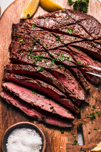 Close up of sliced flank steak on cutting board.