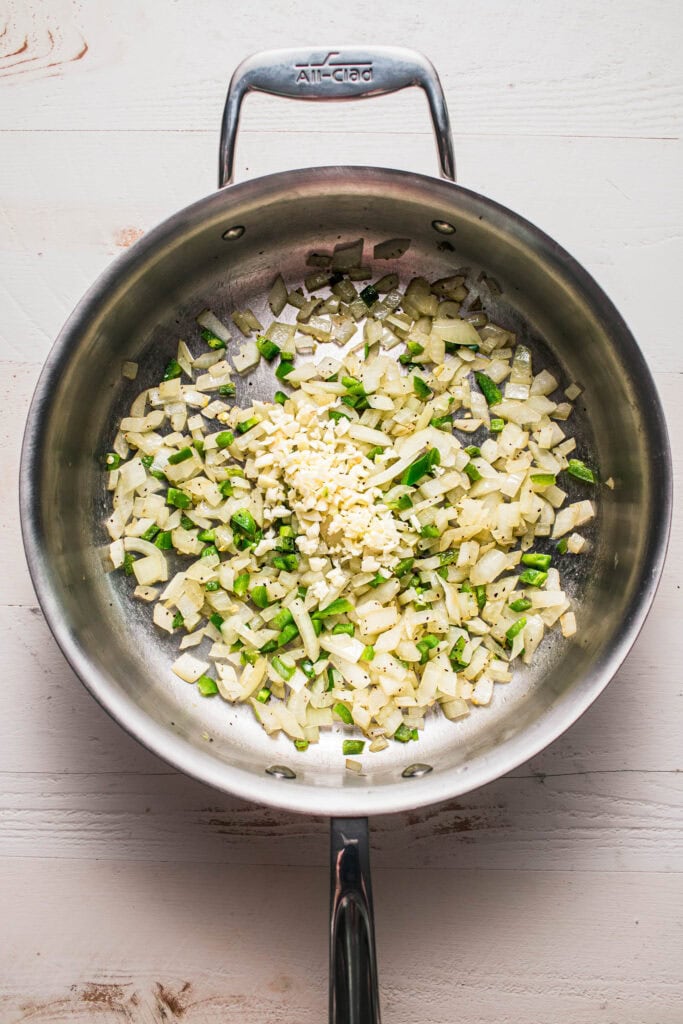Aromatics being sauteed in skillet.