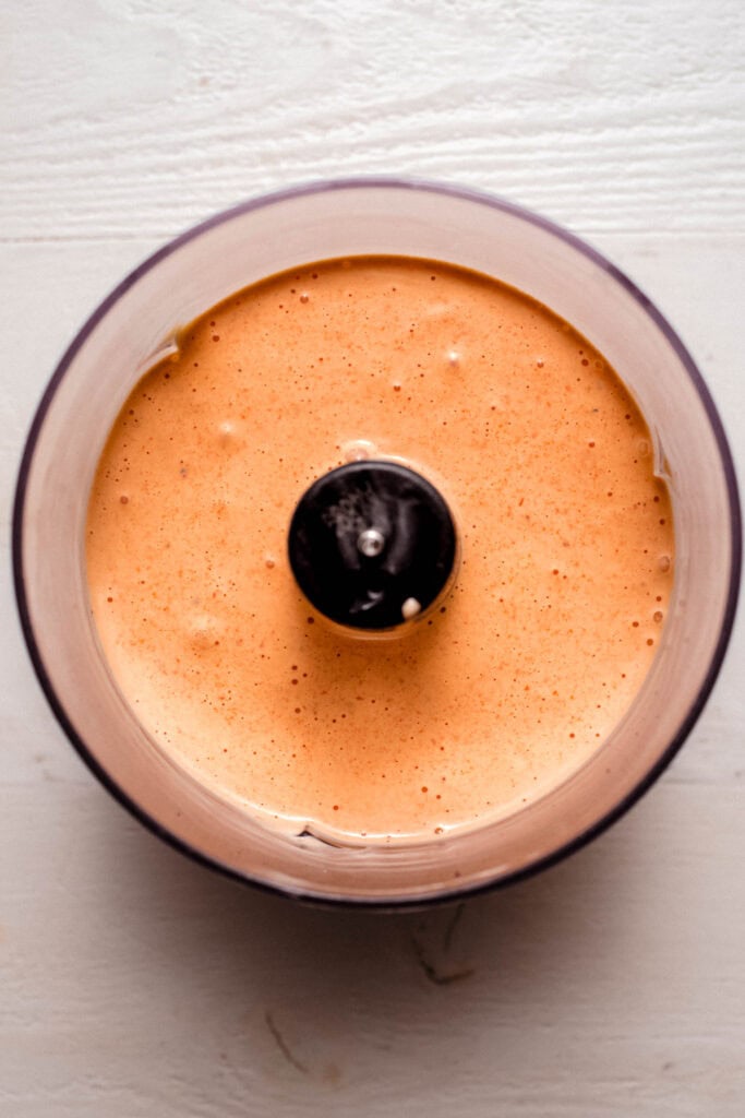 Finished red pepper aioli in food processor bowl.