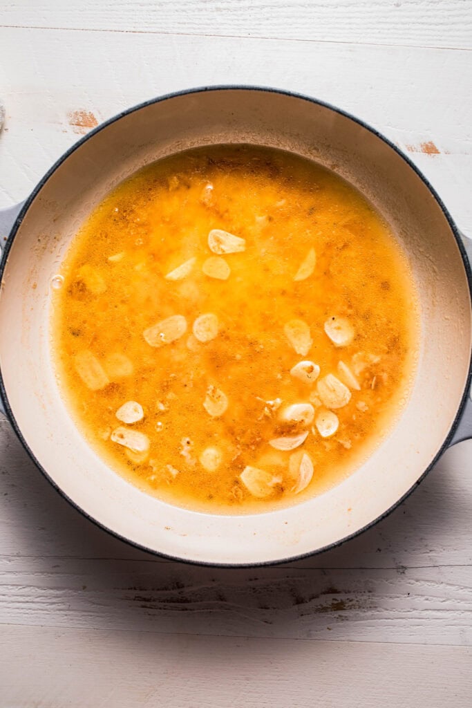 Sauteed garlic and broth in skillet.