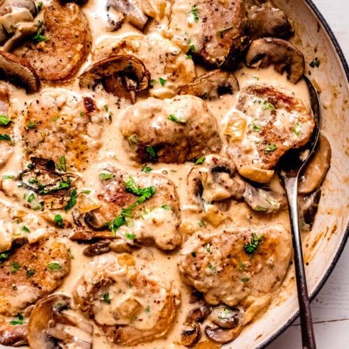 Creamy pork marsala in skillet topped with fresh parsley.