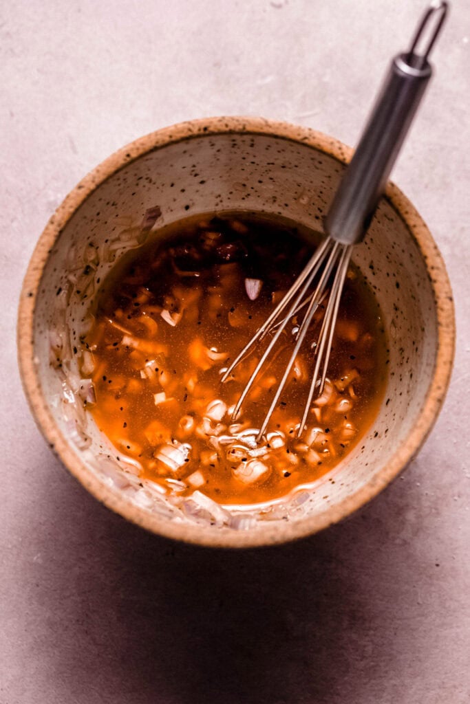 Shallot vinaigrette being whisked together.