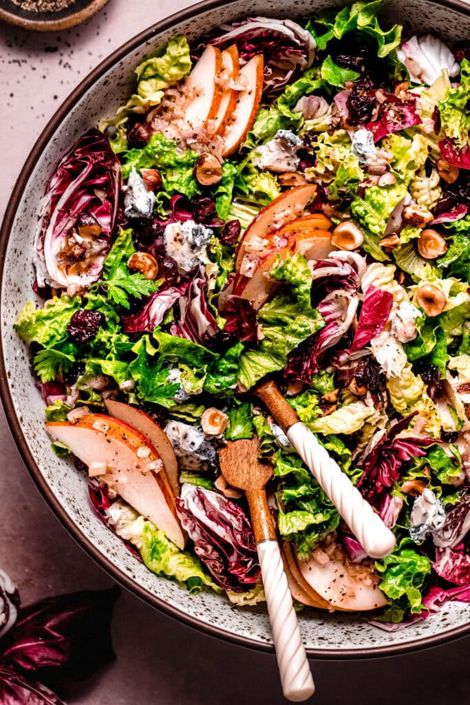 Overhead close up of Thanksgiving fall salad with serving tongs.