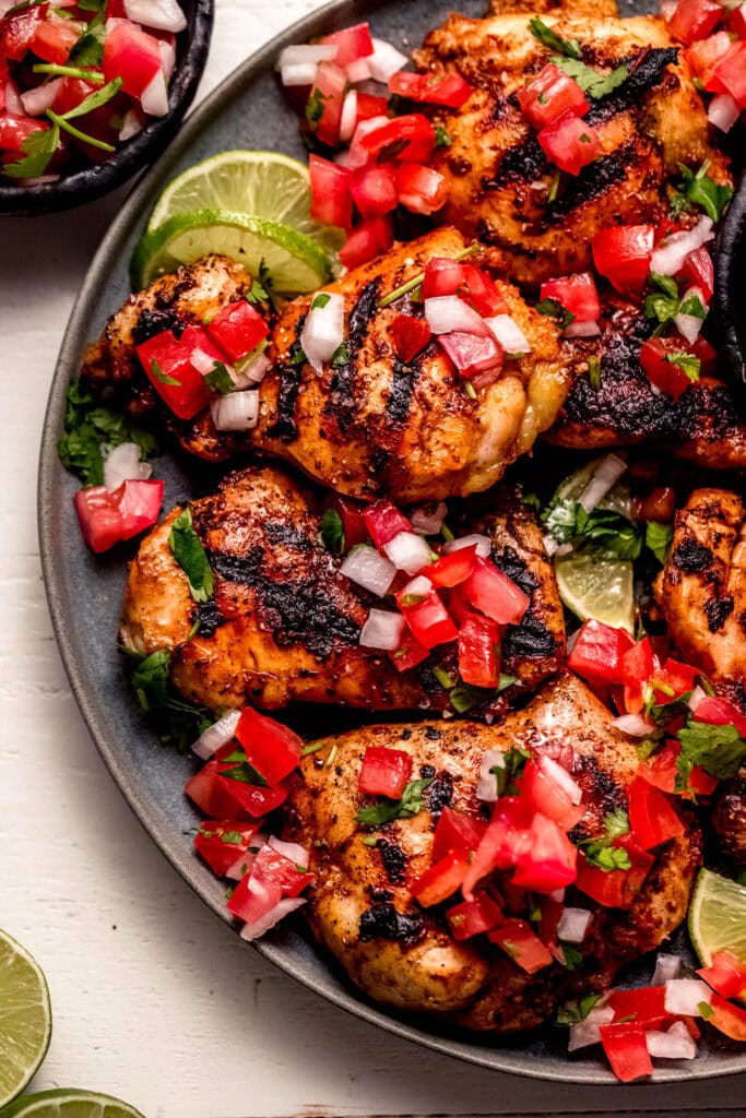 Overhead close up of grilled chicken thighs topped with pico de gallo.
