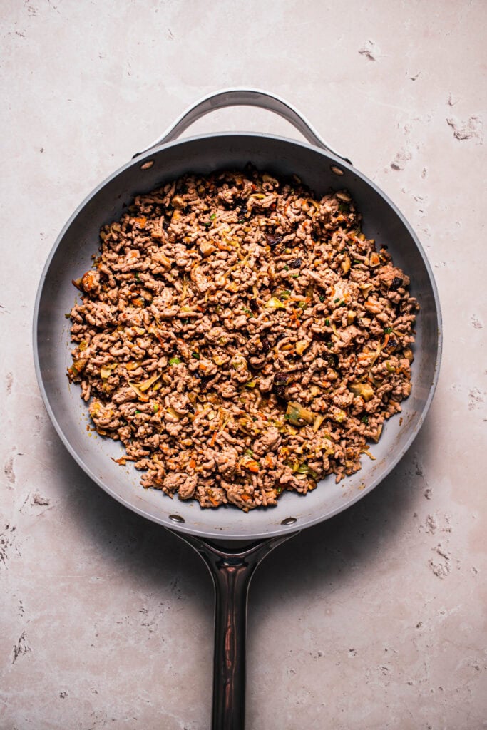 Pork being browned in skillet.