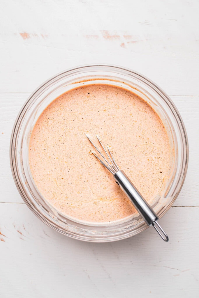 Mexican pasta salad dressing whisked together in bowl.