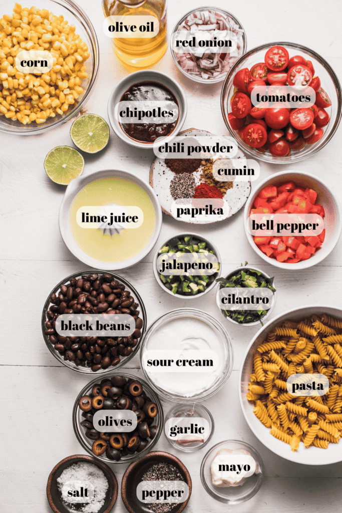 Ingredients for Mexican pasta salad labeled on counter. 
