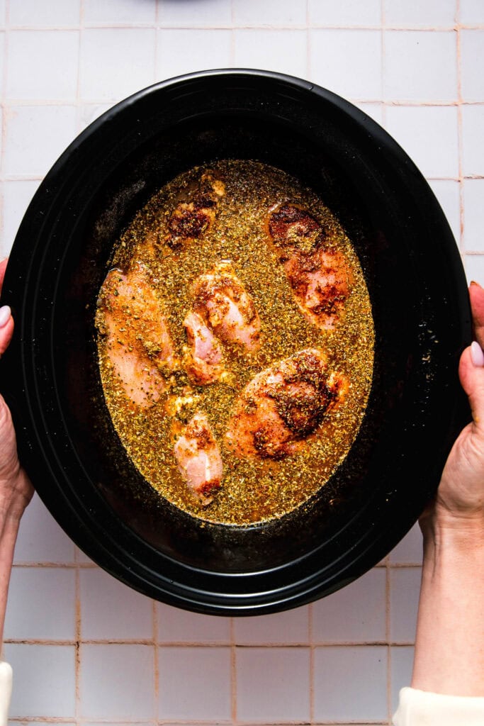 Raw chicken and citrus juices in slow cooker.