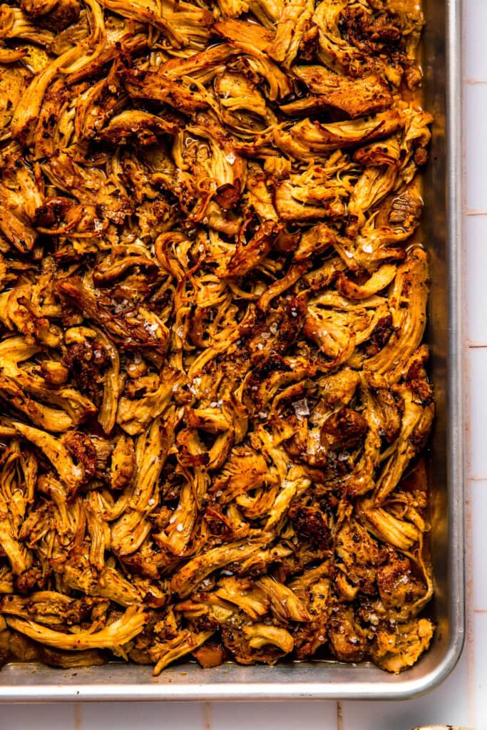 Shredded chicken carnitas on baking sheet.