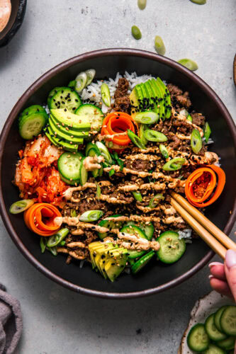 Chopsticks dipping into Korean Beef Rice Bowl.