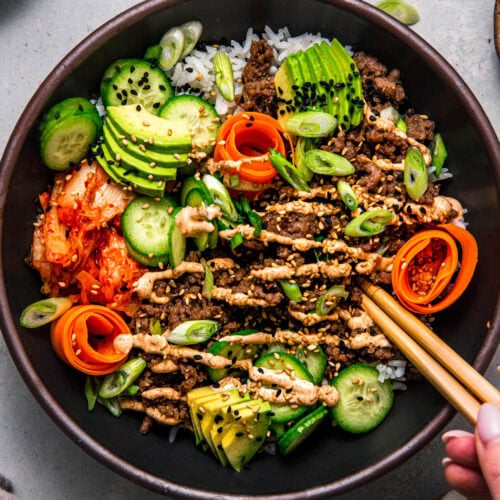 Chopsticks dipping into Korean Beef Rice Bowl.