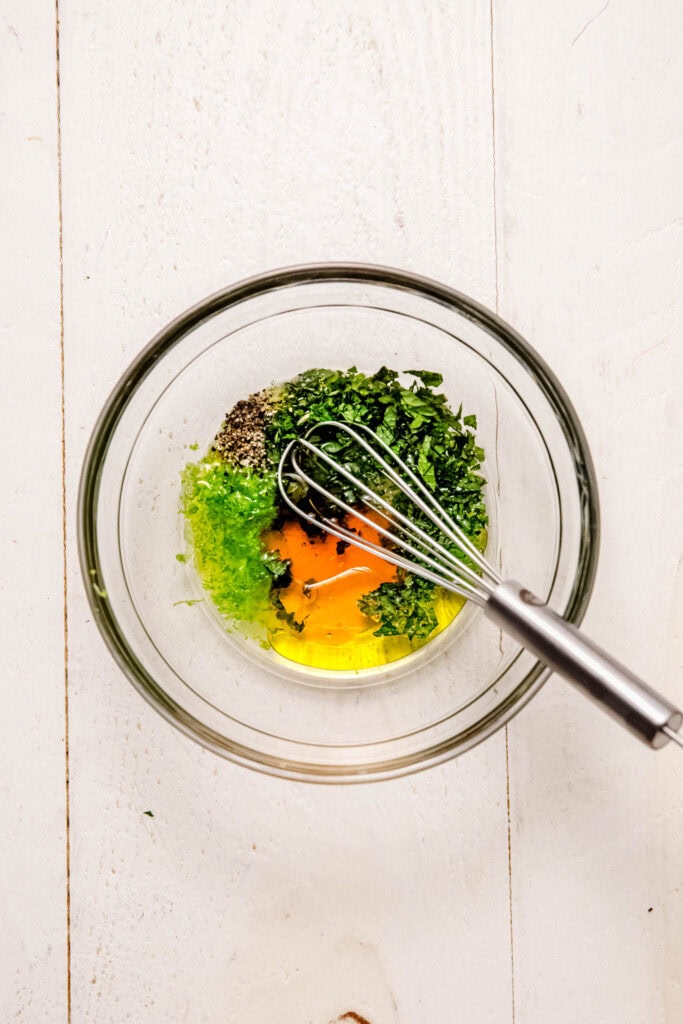 Dressing being whisked together in bowl.