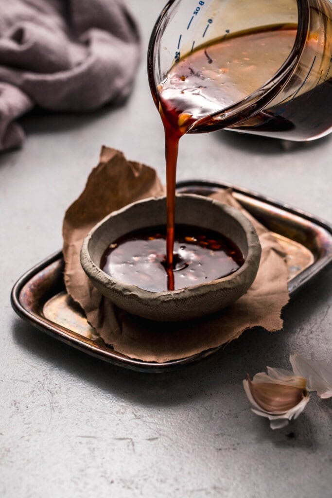 Teriyaki sauce being poured into small bowl.
