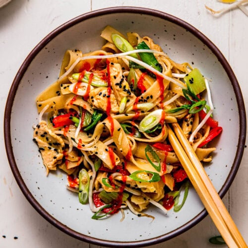 Chicken chow fun in serving bowl with chopsticks.