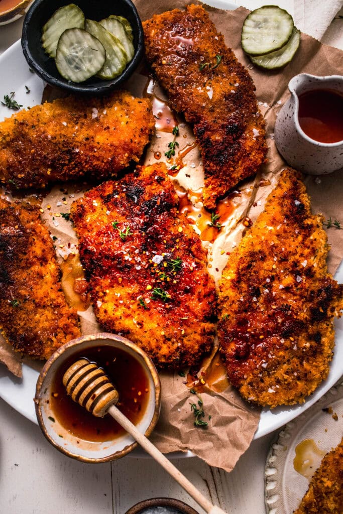 Hot honey chicken arranged on serving platter with honey wand.