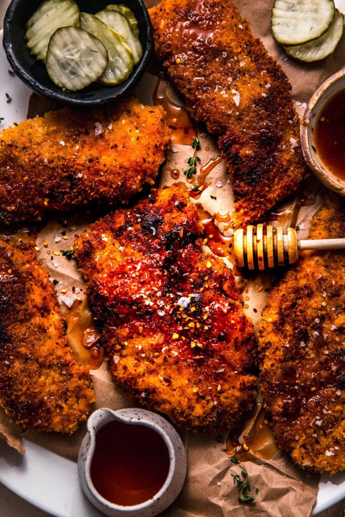 Hot honey chicken arranged on serving platter with honey wand.