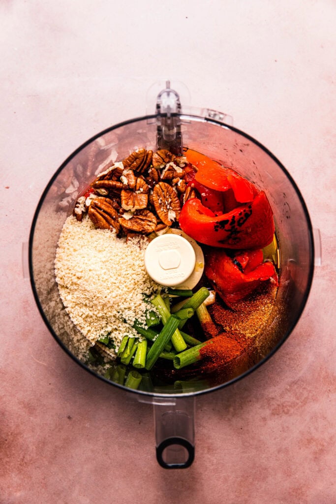 Ingredients for muhammara dip in food processor bowl.