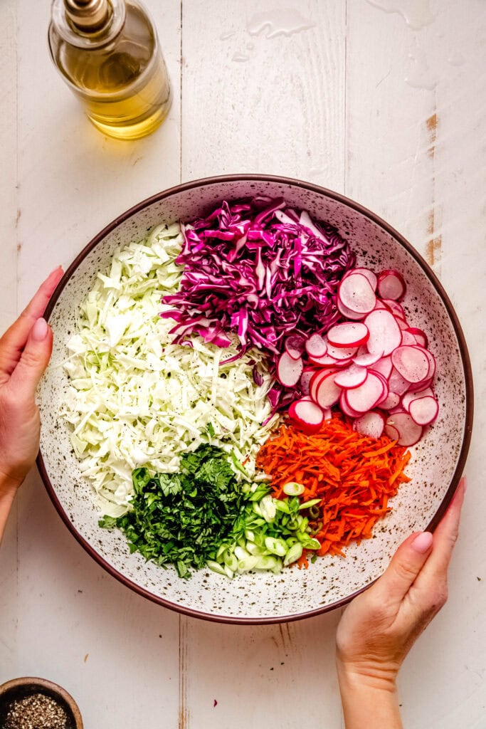 Ingredients for radish slaw added to large bowl.