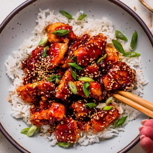 Overhead close up of sweet chili chicken served on bed of rice.