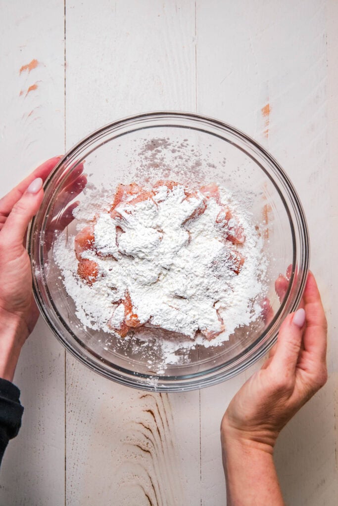 Chicken tossed with cornstarch in bowl.