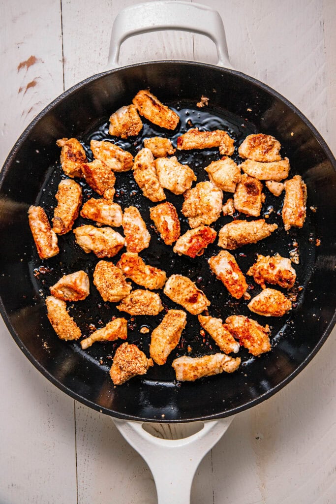 Chicken pieces browning in skillet