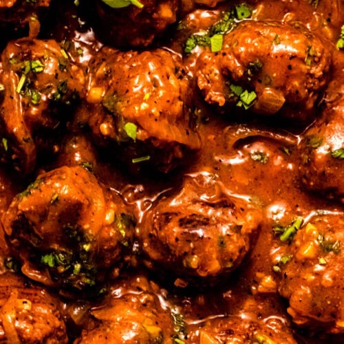 Overhead close up shot of salisbury steak meatballs in skillet.