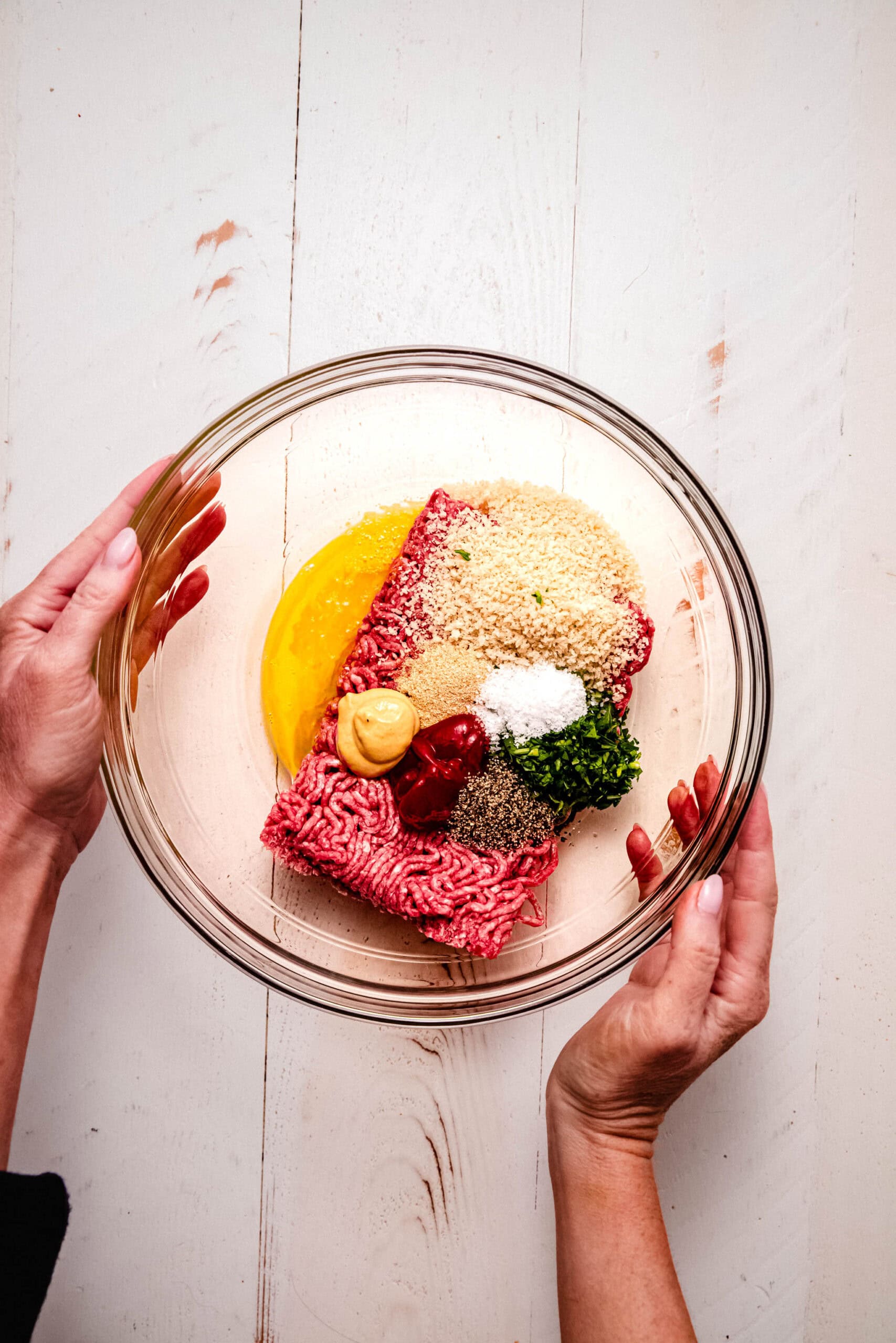Ingredients for meatballs in bowl before mixing.