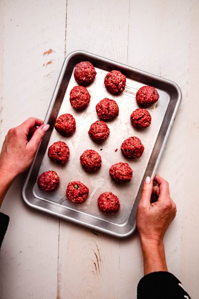Formed meatballs on baking sheet.