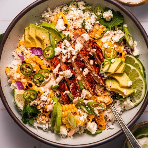 Street corn chicken and rice bowl topped with seasoned chicken, charred corn, and a creamy smoky dressing.