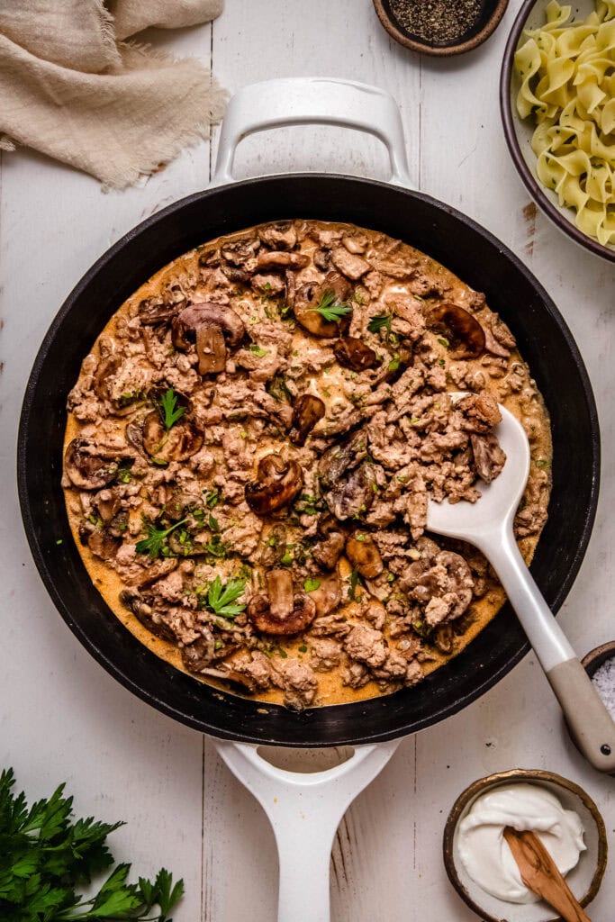 Ground turkey in skillet with mushrooms and cream sauce.