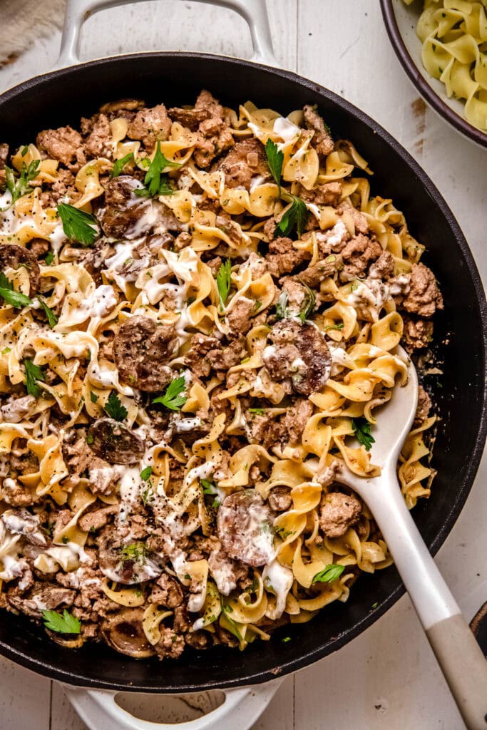 Finished ground turkey stroganoff in skillet with serving spoon.