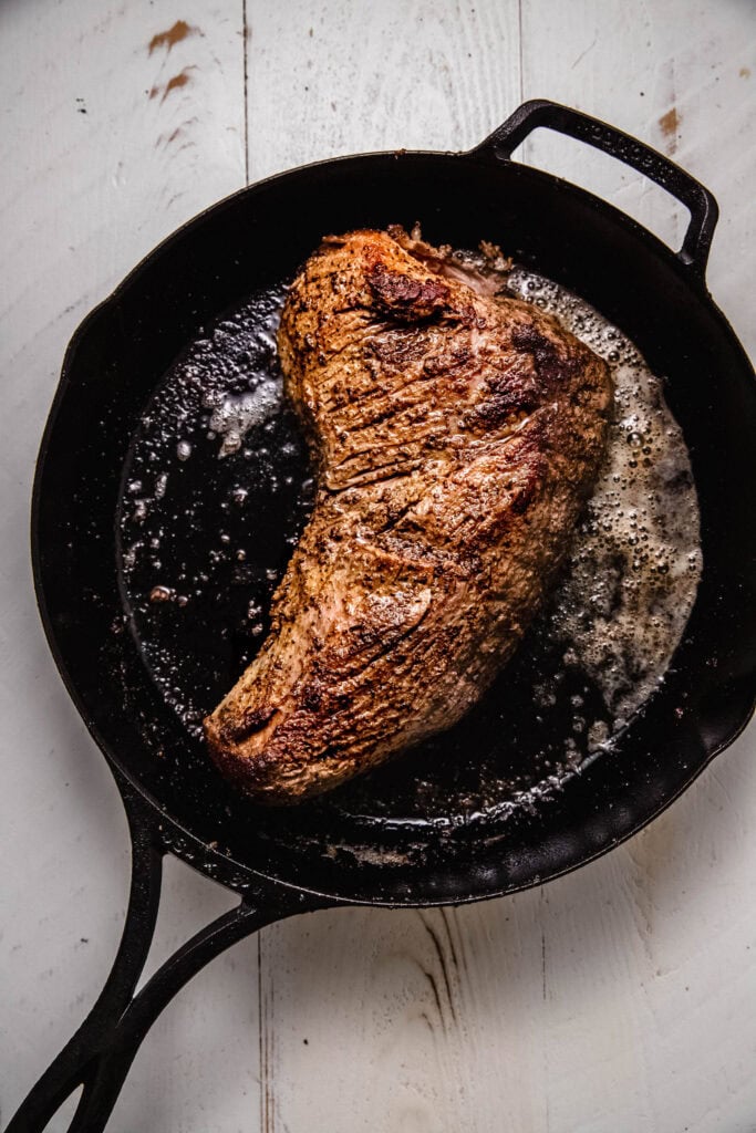 Sous vide tri tip being seared in skillet.
