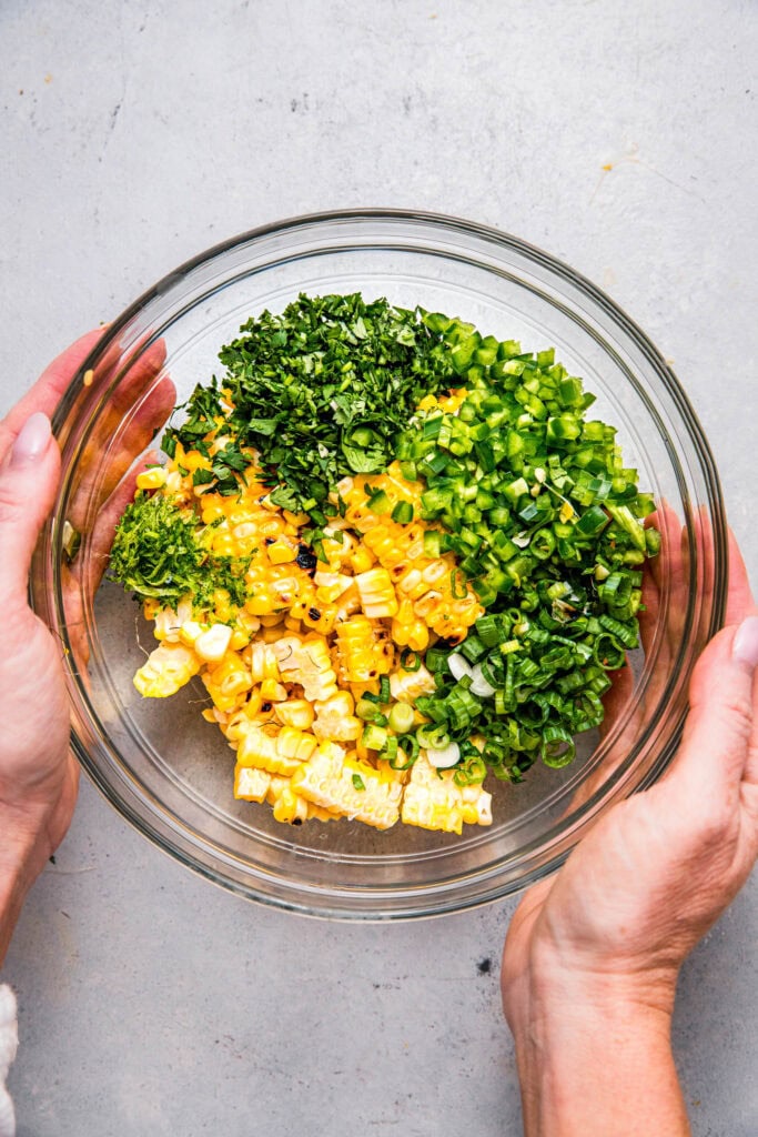 Grilled corn in bowl with cilantro, jalapenos, etc.