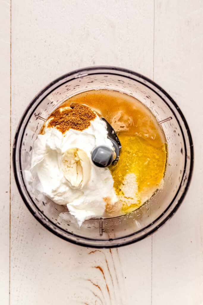 Tahini sauce ingredients in food processor bowl. 