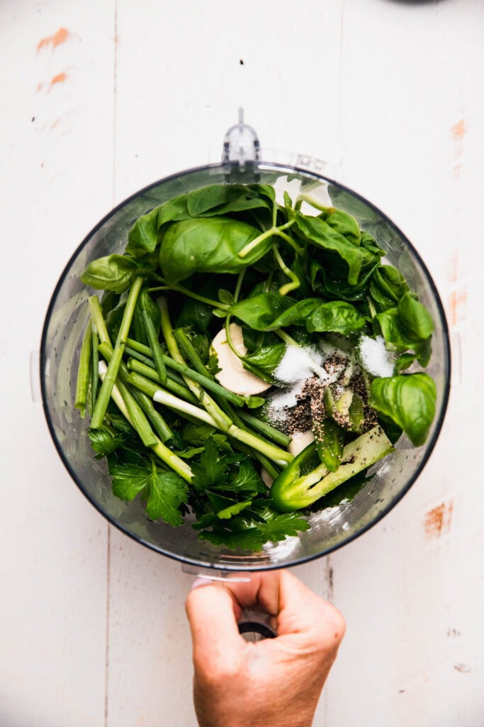 Ingredients for green goddess sauce in food processor bowl. 