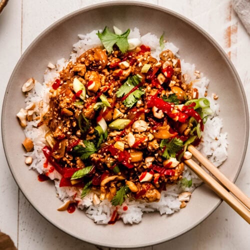 Finished ground pork stir fry in serving bowl with rice.