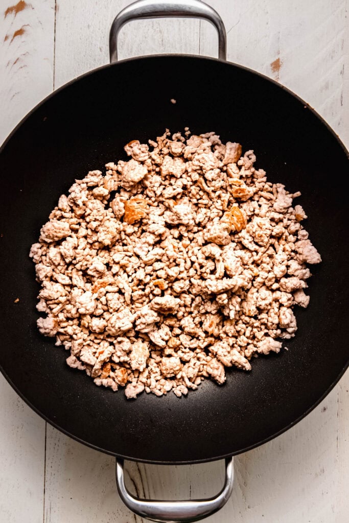 Ground pork browning in wok.
